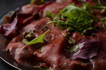 Beef Carpaccio  with parmesan, capers and arugula. With olive oil and soy sauce