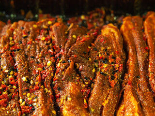 Fresh uncooked pork belly portions marinated with Asian style red spicy sous. Close up. Meat industry product.
