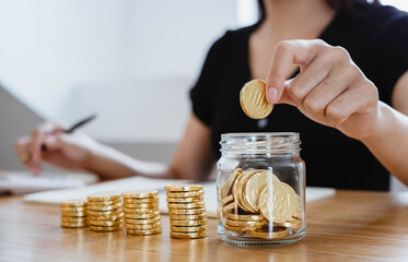saving money with hand putting coins in jug glass concept financial
