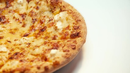 Close up view of pizza with cheese spinning on white background