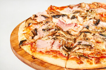 Fresh pizza with bacon, mushrooms and cheese on a light background. Close-up, selective focus