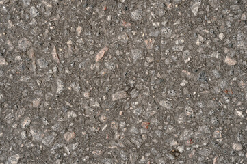 Abstract background of black asphalt with inclusions of pebbles