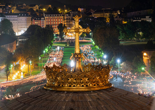 LOURDES, FRANCE - SEPTEMBER 14 2019: Cross in front of the candle procession, every night in Lourdes, France, Europe