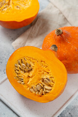 Hokkaido Pumpkin. Sliced pumpkin in a white plate on a light gray table. Pumpkin close up