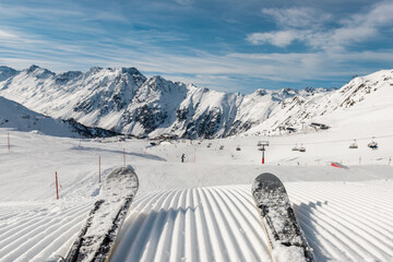 Panorama point of view skier legs on downhill start straight line rows freshly prepared groomed ski...