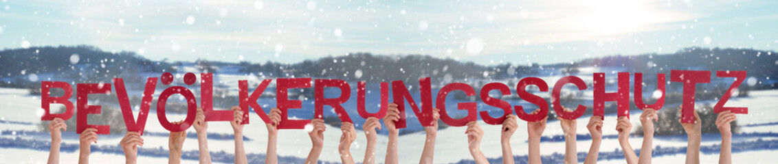 People Hands Holding Colorful German Word Bevoelkerungsschutz Means Civil Defence. Snowy Winter Background With Snowflakes