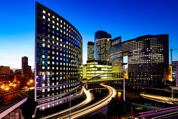 Fototapeta na wymiar Night view of the Paris La Défense business district and headquarters of . corporation and multinational firm illuminated at the blue hours