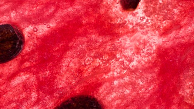 Pressure on Watermelon Slice with Seeds. Slices and slices of watermelon are compressed and crushed close-up on a bright white background, creating a juicy splash of pulp and juice. Shooting at 120 fp