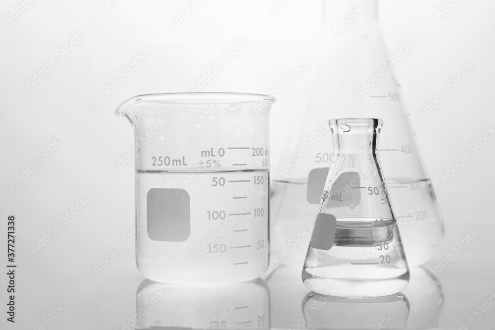 Wall mural clear water in beaker and flask in white science laboratory background