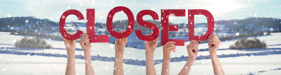 People Hands Holding Colorful English Word Closed. Snowy Winter Background With Snowflakes