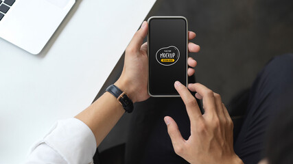 Businessman using mock up smartphone while sitting in his office room