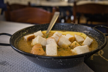 Delicious Italian fish soup with sardines, prawns, shells and bread croutons