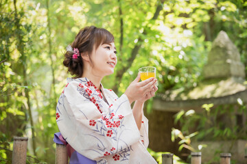 飲み物を飲む浴衣姿の女性
