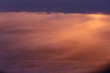 Fototapeta na wymiar Sonnenaufgang oder Sonnenuntergang über den Wolke aus dem Flugzeug fotografiert, der Himmel oist blutrot und schön.