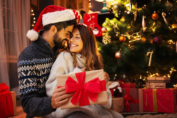 Obraz na płótnie Canvas Man giving a Christmas present to his girlfriend