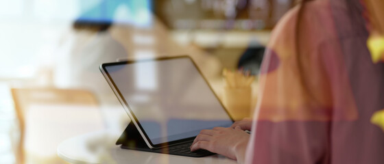 Collage student working on her project with tablet, view through glass view