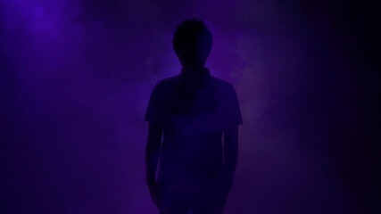紫色のライトの中に立つ男性