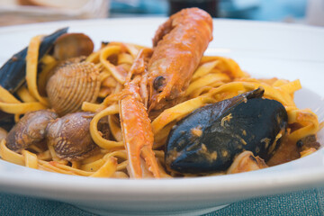 Delicious homemade Italian seafood pasta with shrimps, lobster, calamary, octopus, mussels and shells