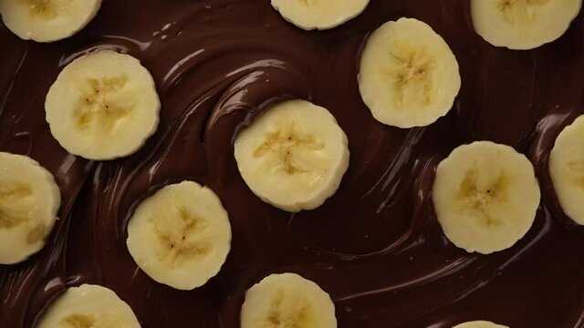 melted chocolate and sliced banana top view rotating