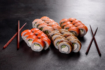 Fresh delicious beautiful sushi rolls on a dark background