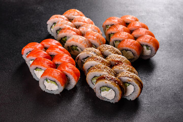 Fresh delicious beautiful sushi rolls on a dark background