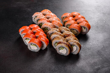 Fresh delicious beautiful sushi rolls on a dark background