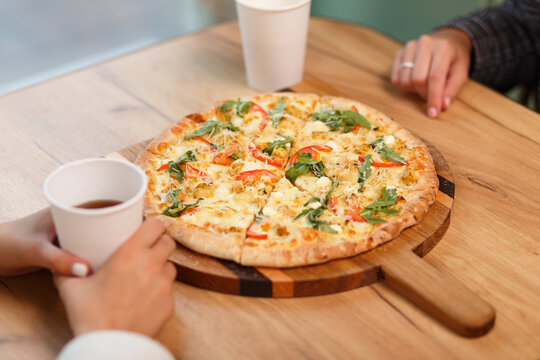 Close-up image of friends sharing traditional Italian pizza