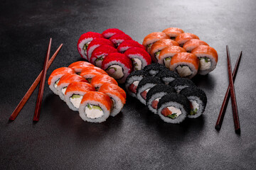 Fresh delicious beautiful sushi rolls on a dark background
