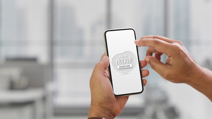 Hands using mock up smartphone on blurred indoor background