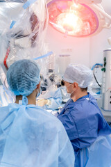 Neurosurgeons providing operation. Operation on brain with new equipment. Selective focus from the...