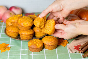 autumn pumpkin cupcakes with fresh pumpkin for thanksgiving day. autumn composition of pumpkin and maple leaves with baked muffins. the cupcake is broken into pieces