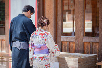 お参りする浴衣姿の男女
