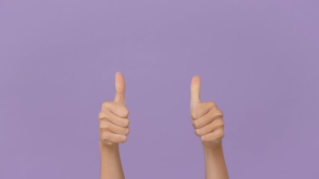 Close up cropped woman hand pointing fingers on you to camera say cool approval showing thumbs up gesture like sign isolated on purple violet background in studio. Advertising area workspace mock up