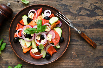 Classic Greek salad with feta on a wooden background.