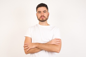 Fototapeta premium Picture of angry young handsome man standing isolated over bright background. Looking camera.