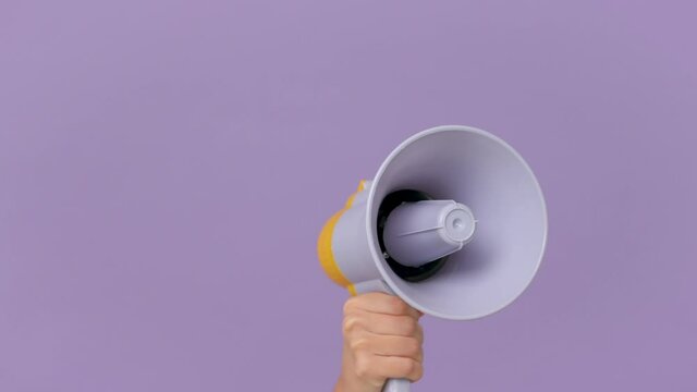 Close up cropped woman hold in hand bullhorn public address megaphone isolated on purple violet background studio. Hot news announce discounts sale hurry up communication concept. Copy space mock up