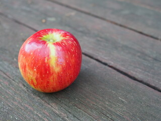 Red apple on gray old wooden table from above, with copy space.