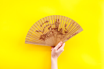 The concept Bamboo fan on Yellow background top view copy space