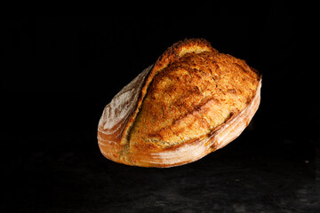 Rustic bread floating on dark background