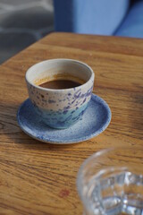 Espresso on a small cup with a glass of water