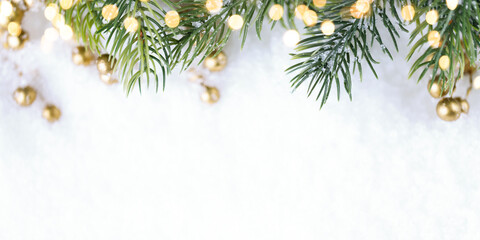 Christmas tree with golden lights on snow.