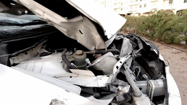 Totally wracked car after accident. Broken car on the side of the road. Body of the car is damaged as a result of an accident. High speed head on a car traffic accident. Concept of car insurance