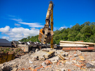 Hydraulic Excavator grab arm moving a demolished wall