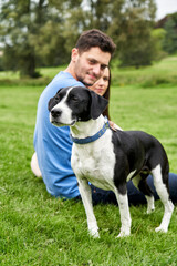 Young couple sitting with pet dog