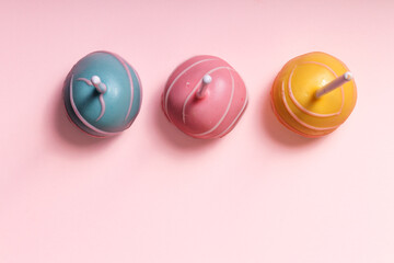 Children birthday party and holiday concept with Three sweet jummy cake-pops top view against pink background. Blue, pink yellow. Flatly. Flatlay.