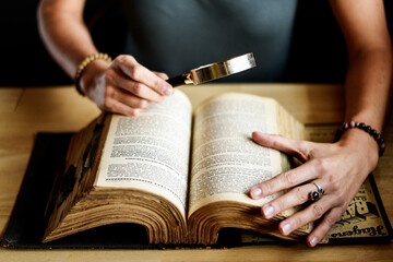 Naklejka premium Reading a book through a magnifying glass