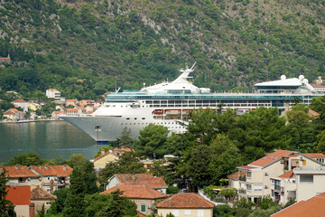     Beautiful white ship in the bay of Kotor on the background of mountains and houses with tiled...