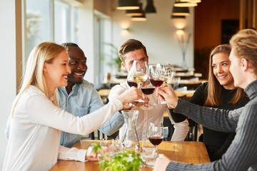 Freunde stoßen an mit Wein und feiern
