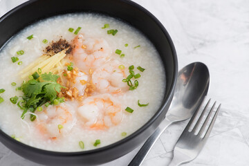 Black bowl of Shrimp porridge, Thai rice soup with shrimp (Khao Tom Koong)