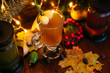 citrus tea in transparent mug with apple, feijoa  and lychee on the table in restaurant